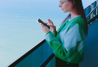 a woman in a green sweater using her phone