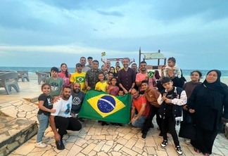 O grupo de brasileiros repatriados de Gaza ao lado de diplomatas brasileiros e da equipe de resgate em Al-Arish, onde pararam para almoçar antes de seguir para o Cairo, no Egito. Foto: GOV.BR