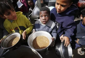 Crianças palestinas buscam alimento em Deir al-Balah, na Faixa de Gaza, em 1° de março de 2024 [Ashraf Amra/Agência Anadolu]