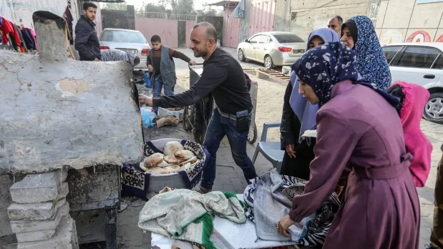Palestinos fazem pão sob os bombardeios de Israel, em Rafah, no sul de Gaza, em 20 de dezembro de 2023 [Abed Rahim Khatib/Agência Anadolu]