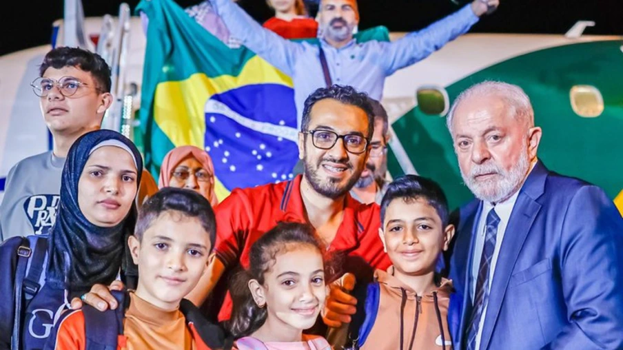 Mohammed (de vermelho) posa com o presidente Lula ao lado da família repatriada no voo com o grupo de Gaza. Foto: Ricardo Stuckert / PR