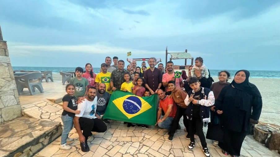 O grupo de brasileiros repatriados de Gaza ao lado de diplomatas brasileiros e da equipe de resgate em Al-Arish, onde pararam para almoçar antes de seguir para o Cairo, no Egito. Foto: GOV.BR