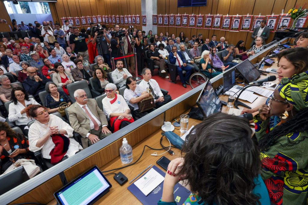 Cartazes com os rostos de mineiros desaparecidos políticos foram afixados nas paredes do auditório
